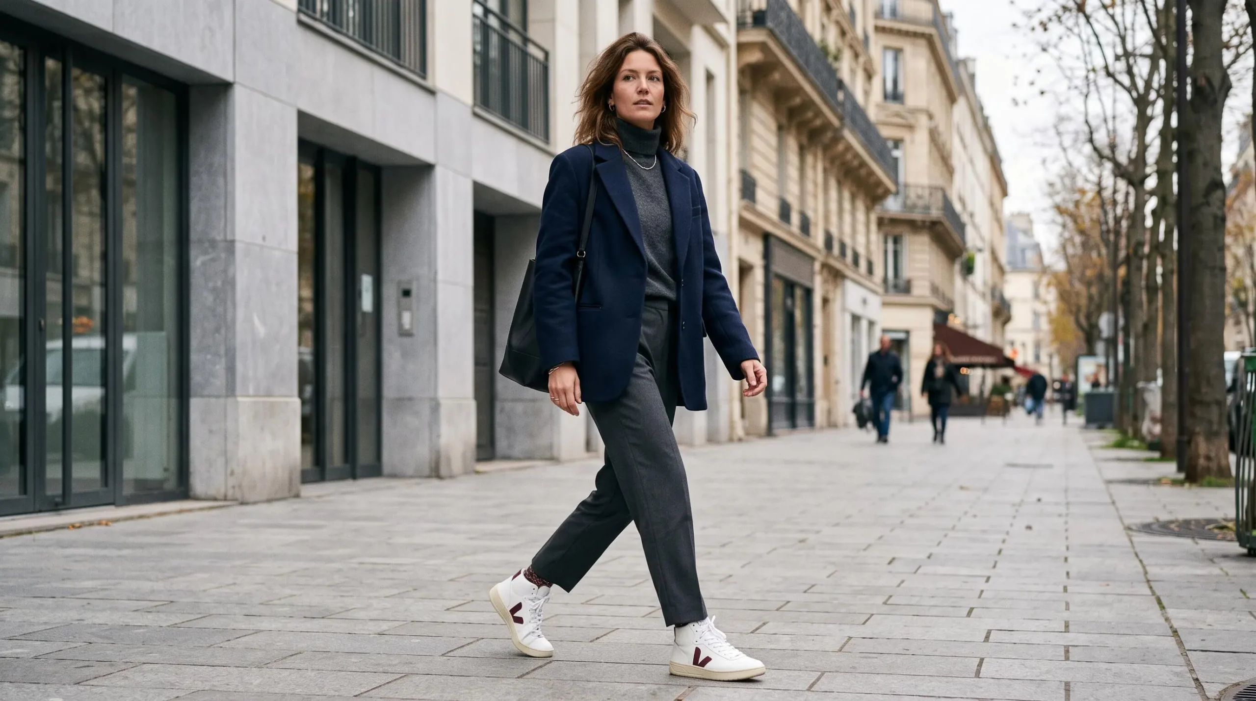 Person walking through a Parisian street wearing high-top sneakers with casual-chic outfit